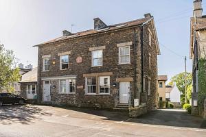 a brick house with a car parked in front of it at Shamrock, Bowness on Windermere, Superb one bedroom apartment with private parking in Bowness-on-Windermere