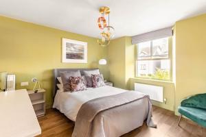 a bedroom with a bed and a chandelier at Shamrock, Bowness on Windermere, Superb one bedroom apartment with private parking in Bowness-on-Windermere