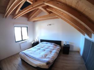 Schlafzimmer mit einem Bett in einem Zimmer mit Holzbalken in der Unterkunft Maison neuve proche de Barcelonnette in Jausiers