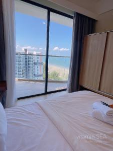 Bett in einem Hotelzimmer mit einem großen Fenster in der Unterkunft vitamin SEA Timurbay Residence in Kuantan