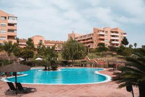 basen z krzesłami i budynkami w tle w obiekcie Precioso apartamento con espectaculares vistas w mieście Alhaurín de la Torre