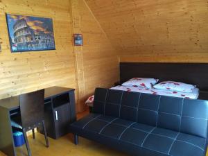 a bedroom with a bed and a couch in a room at Zrub Nová Lesná in Nová Lesná