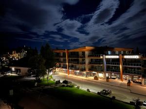 a building with a parking lot in front of it at night at Apartmán Sivý vlk Hrebienok Rezort in Smokovce +8 photos
