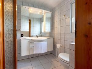 bagno con lavandino, servizi igienici e specchio di Ferienbungalow Schultz in Altenkirchen ad Altenkirchen