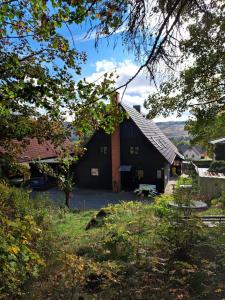 a large black barn with a yard and trees at Haus Erna Schierke in Schierke