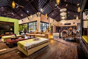 a large living room with couches and tables at Lautan Kupu - Kupu Villas in Canggu