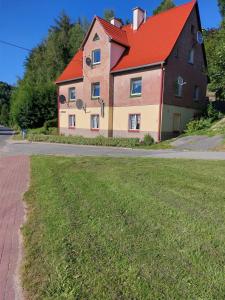una casa grande con techo rojo en una calle en Apartament Rosiczka en Duszniki Zdrój
