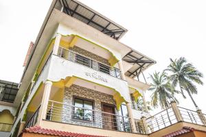 - un bâtiment jaune et blanc avec balcon dans l'établissement Dhanashree Riverview Hotel, à Corgao