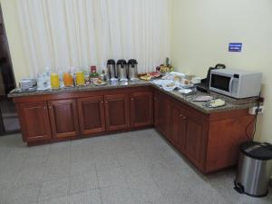 a kitchen with a counter with a microwave on it at Hotel Domingo Savio in Encarnación