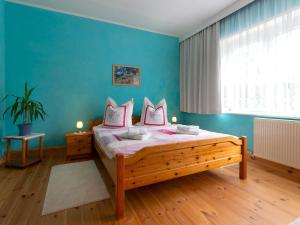 a bedroom with a bed and a blue wall at Ferienwohnung Käthe in Altenkirchen in Altenkirchen
