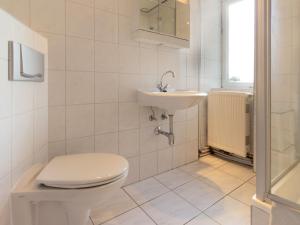 a white bathroom with a toilet and a sink at Ferienwohnung Käthe in Altenkirchen in Altenkirchen