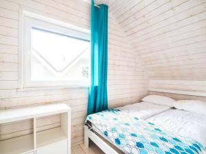 a small bed in a room with a window at Holiday House Sarbinowo in Sarbinowo