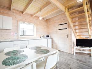- une cuisine avec une table blanche et des chaises blanches dans l'établissement Holiday House Sarbinowo, à Sarbinowo