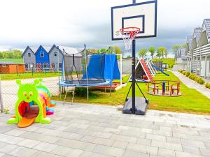 un parque con un aro de baloncesto y un parque infantil en Holiday House Sarbinowo, en Sarbinowo