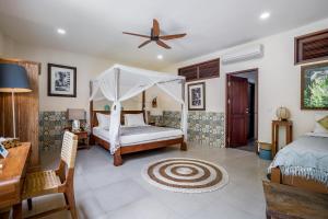 a bedroom with a bed and a ceiling fan at Lautan Kupu - Kupu Villas in Canggu