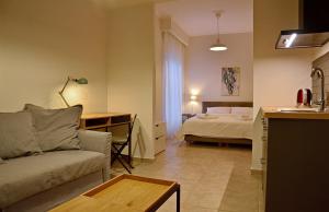 een woonkamer met een bank en een bed bij Eutopia Luxury Studio in Kavala