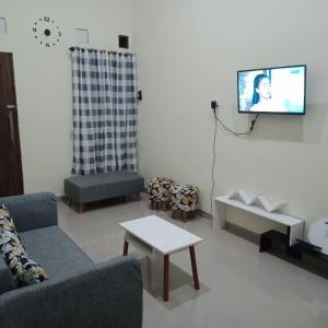 a living room with a couch and a tv on a wall at Lavanta Guest House 