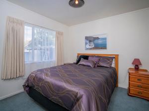 - une chambre avec un lit et une fenêtre dans l'établissement The Bach - Whangamata Holiday Home, à Whangamata