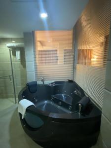 a large black bath tub in a bathroom at City Center Hotel in Mawāliḩ