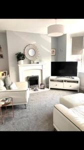 un soggiorno con divano bianco e camino di 8 Guests House Wow a Coventry