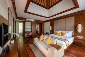 1 dormitorio con 1 cama grande y TV en Tanadewa Villas Nusa Dua Bali by Cross Collection, en Nusa Dua