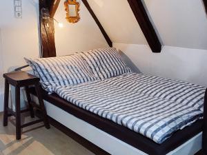 Una cama pequeña con una sábana rayada azul y blanca en Ferienwohnung Dachstüble, en Blaubeuren