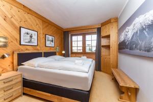a bedroom with a bed and a wooden wall at Appartements Planai by Schladmingurlaub in Schladming