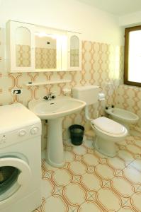 ein Badezimmer mit einem Waschbecken und einer Waschmaschine in der Unterkunft Casa Katya in Pracorno di Rabbi