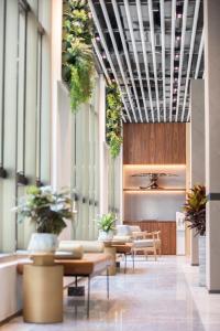 um átrio com mesas e vasos de plantas nos tectos em Hotel Madera Hong Kong em Hong Kong