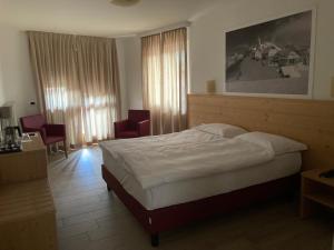 Habitación de hotel con 1 cama y 2 sillas en Hotel Nevada, en Tarvisio