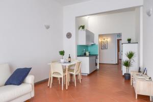 uma cozinha e uma sala de estar com mesa e cadeiras em [LE CURE] Large apt, 6+1 beds. Center 15 min far by bus. em Florença