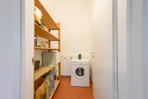 uma lavandaria com máquina de lavar e secar roupa em [LE CURE] Large apt, 6+1 beds. Center 15 min far by bus. em Florença