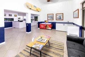 sala de estar con sofá, mesa y tabla de surf en la pared en BIG4 Manning Point Holiday Park, en Manning Point