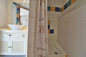 a bathroom with a shower curtain and a sink at Chambre d'hôtes La Détente - Domaine la Rose des vents in Castelnau-sur-lʼAuvignon