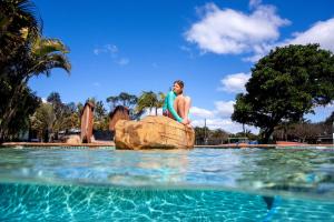 um homem de pé numa rocha no meio de uma piscina em BIG4 Manning Point Holiday Park em Manning Point