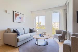 salon z kanapą i stołem w obiekcie Uma Suites O'Donnell w Madrycie