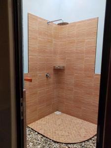 a bathroom with a shower with brown tile at Saima Inn in Maalhos