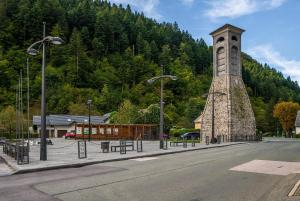 una torre dell'orologio sul lato di una strada di Haus Lagma Studio a Železniki
