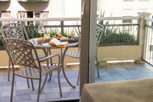una mesa con sillas y un libro en el balcón en La Musa Apartments & Rooms, en Palermo