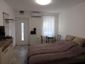 1 dormitorio con 1 cama y 1 mesa con sillas en Szépasszonyvölgy Apartman, en Eger