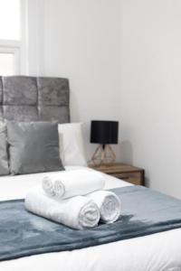 a pile of towels sitting on top of a bed at Beautiful flat next to city centre in Liverpool