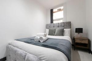 a bedroom with a large bed with towels on it at Beautiful flat next to city centre in Liverpool