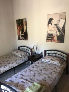 ein Schlafzimmer mit 2 Betten und einem Wandgemälde in der Unterkunft AnaMar Eternity House in Asprókambos