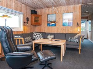 a living room with a couch and a table and chairs at 8 person holiday home in Glesborg in Bønnerup