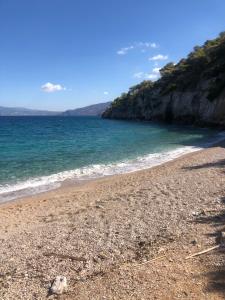 a beach with the ocean and a rocky shore at AnaMar Eternity House in Asprókambos