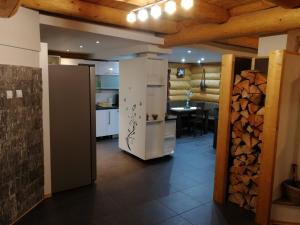 a kitchen with a refrigerator and a table in a room at Zrub Nová Lesná in Nová Lesná