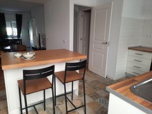 eine Küche mit zwei Barhockern und einer Theke in der Unterkunft Casa Amapola - Costa Bahía de Cádiz in Puerto Real