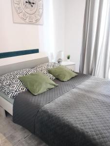 een bed met twee groene kussens in een slaapkamer bij Apartament Leśny in Lubin