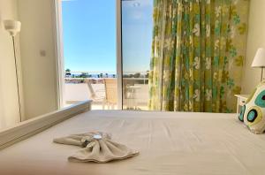 um quarto com uma cama com uma toalha em Nissi 3 C14 Sea View Top Floor Apartment em Agia Napa