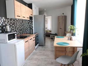 a kitchen with a white refrigerator and a table at Apartament Leśny in Lubin